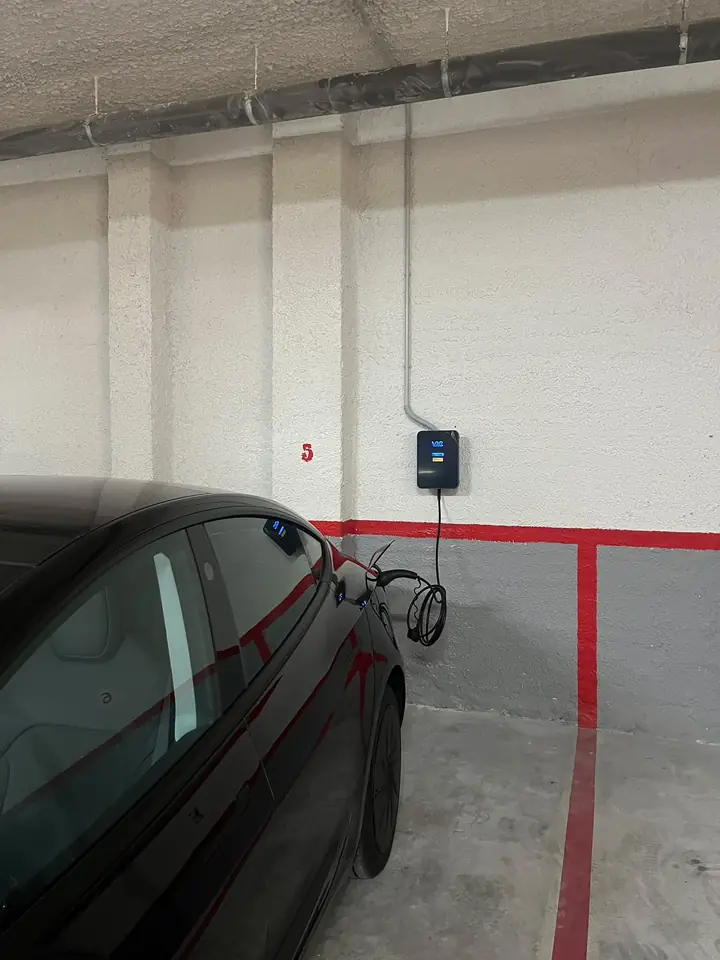Punto de carga V2C en una plaza de garaje con un coche eléctrico cargando